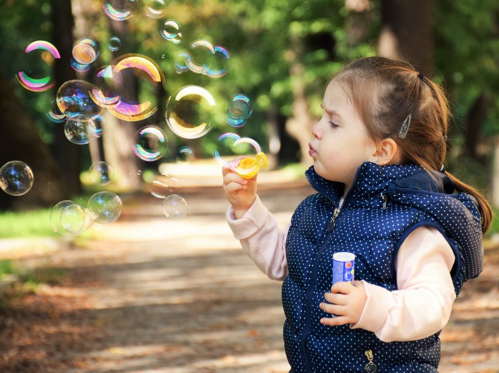 little girl blowing bubbles